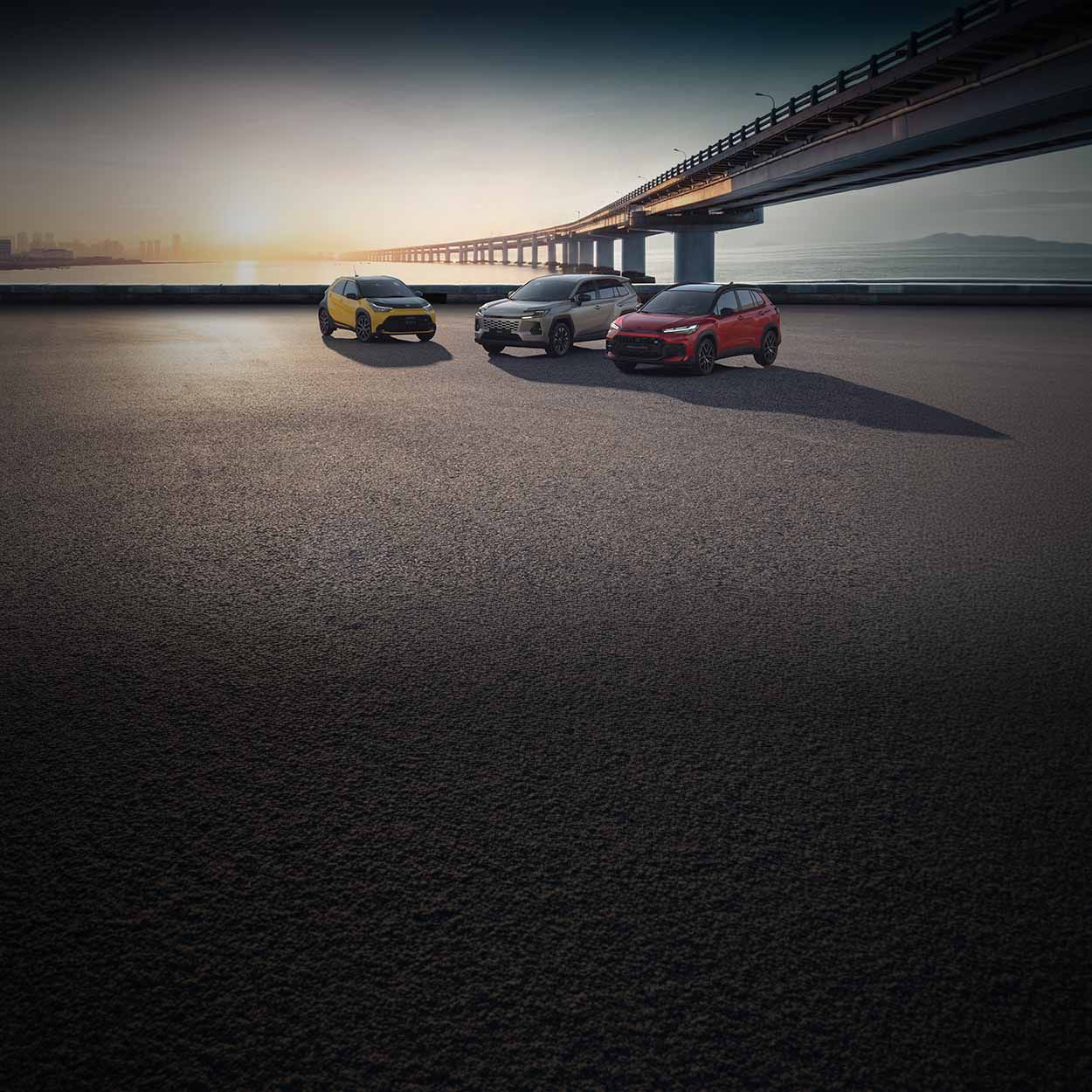 Verschiedene Toyota Hybrid Modelle vor einem Fluss mit Brücke